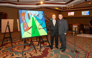 Friends United founder Rolf Bouman and artist Lorne E. Julien beside Lorne E. Julien's artwork at the Halifax Exhibition 2013 at Casino Nova Scotia in Halifax, Nova Scotia.