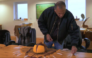 Eric Schweig finishing a mask at Friends United