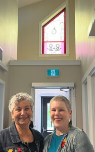 Shannon Monk and Melinda Robertson beneath the traditional window they created for the Indigenous Women’s Shelter